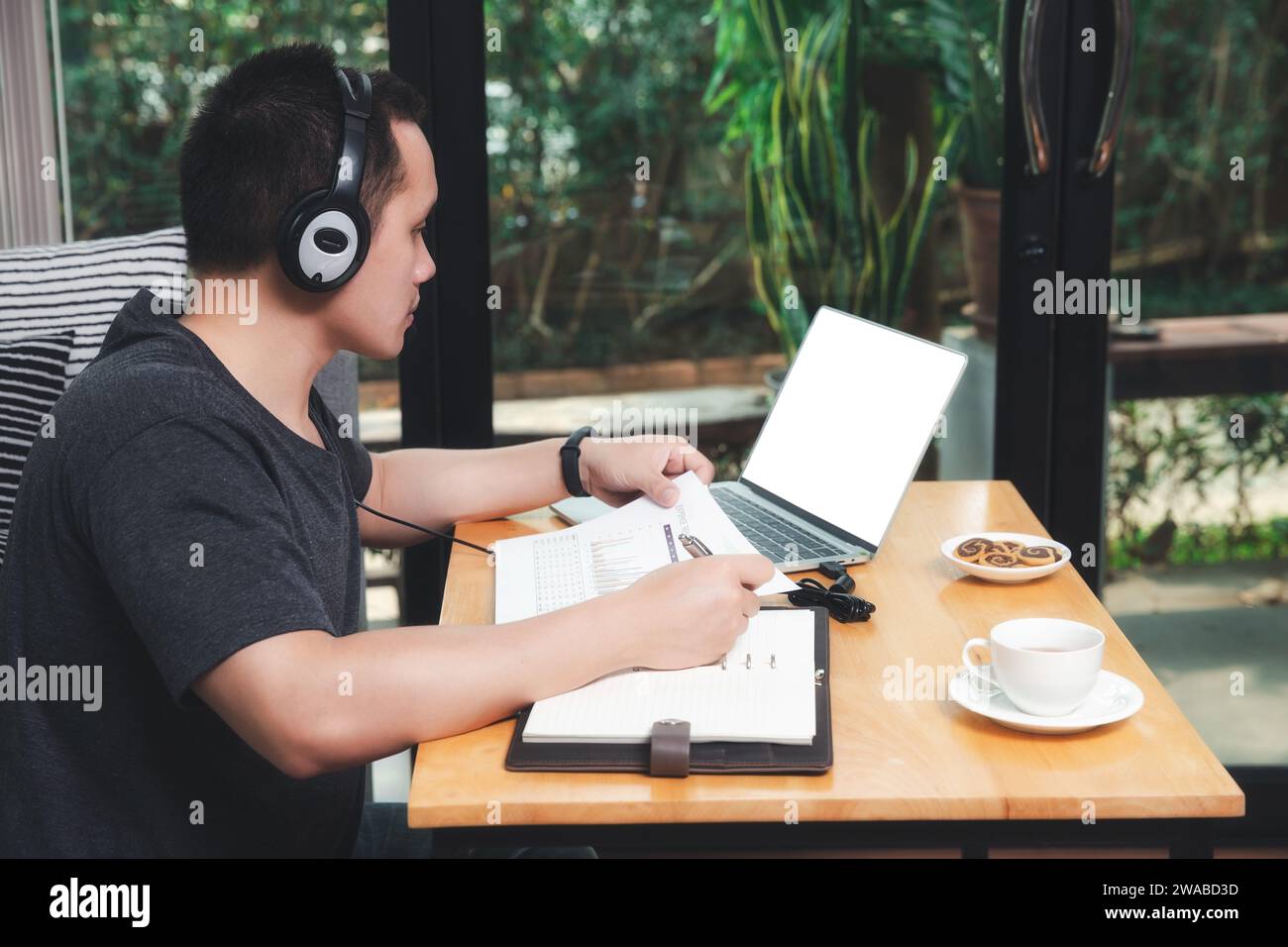 Videochiamata con i clienti sul computer portatile in ufficio. Uomo indossa le cuffie video chiamata o corso online di formazione a distanza e-pendente. Foto Stock