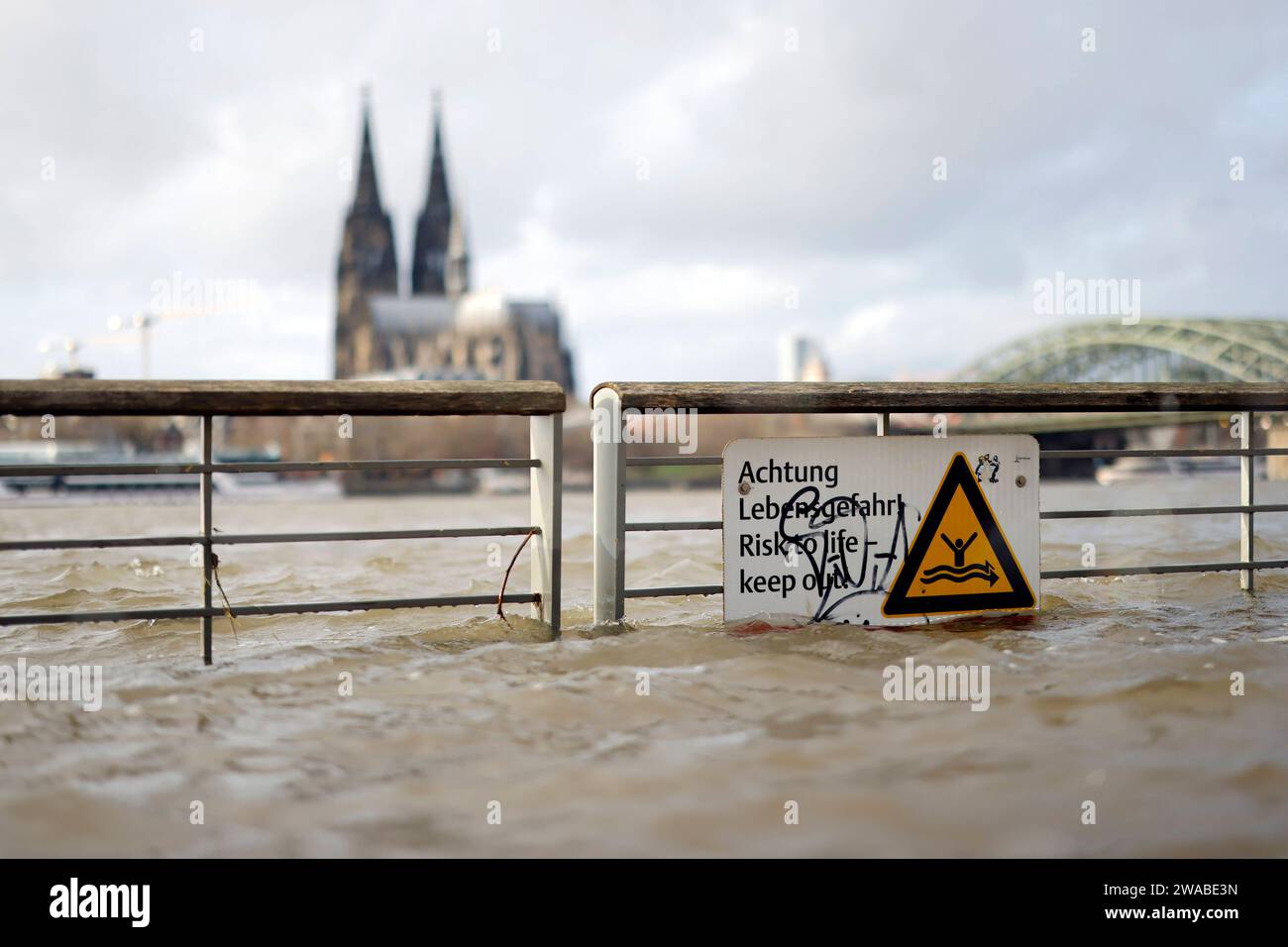Impression vom Hochwasser in Köln am Ufer von Köln-Deutz: Am Ufer des Rhein sind Teile des Rheinboulevard, Gehwege und Wiesen überflutet. Absperrungen weisen auf Lebensgefahr bei Hochwasser Hin. DAS nasse Wetter Hat die Pegel von Bächen und Flüssen steigen lassen. Böden sind aufgeweicht und können kein weiteres Wasser fassen. für die kommenden Tage wird Dauerregen befürchtet. Themenbild, Symbolbild Köln, 03.01.2023 NRW Deutschland *** impressione delle inondazioni a Colonia sulle rive di Colonia Deutz sulle rive del Reno, parti del RheinBoulevard, sentieri e prati sono allagati Bar Foto Stock