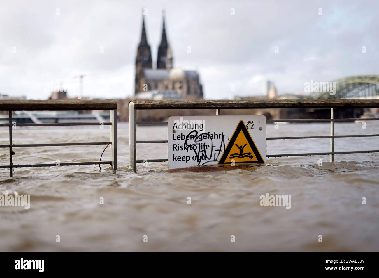 Impression vom Hochwasser in Köln am Ufer von Köln-Deutz: Am Ufer des Rhein sind Teile des Rheinboulevard, Gehwege und Wiesen überflutet. Absperrungen weisen auf Lebensgefahr bei Hochwasser Hin. DAS nasse Wetter Hat die Pegel von Bächen und Flüssen steigen lassen. Böden sind aufgeweicht und können kein weiteres Wasser fassen. für die kommenden Tage wird Dauerregen befürchtet. Themenbild, Symbolbild Köln, 03.01.2023 NRW Deutschland *** impressione delle inondazioni a Colonia sulle rive di Colonia Deutz sulle rive del Reno, parti del RheinBoulevard, sentieri e prati sono allagati Bar Foto Stock