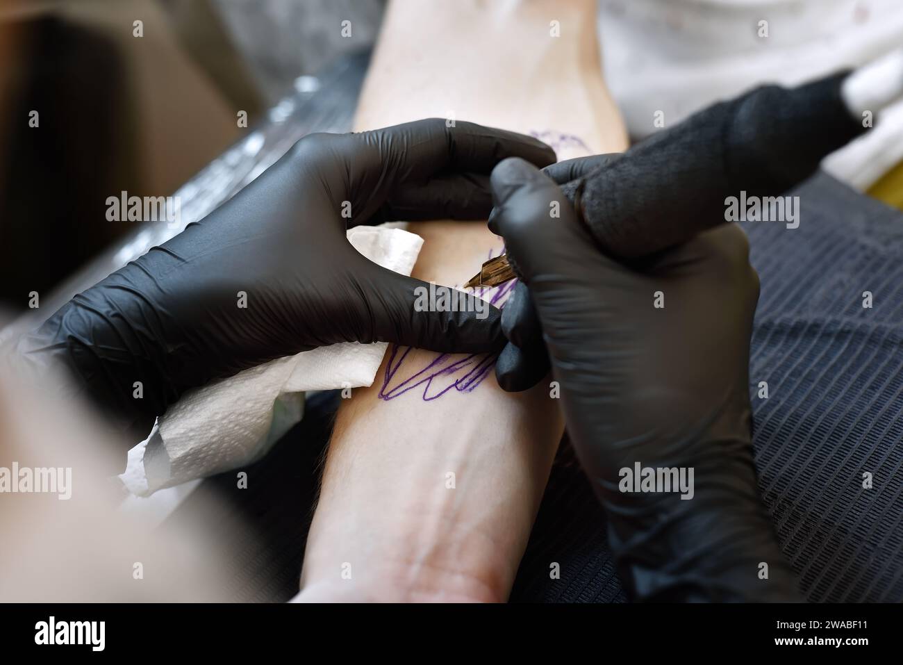 Primo piano di una donna tatuatrice che fa un tatuaggio. Concetto di arte e design. Foto Stock