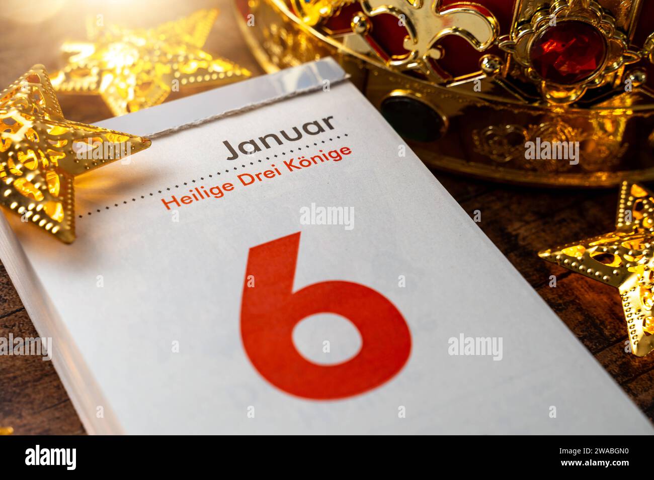 3 gennaio 2023: Festa dell'Epifania il 6 gennaio su una pagina del calendario accanto a una corona e stelle d'oro *** Heilige Drei Könige Feiertag am 6 Januar auf einem Kalenderblatt neben einer Krone und goldenen Sternen Foto Stock