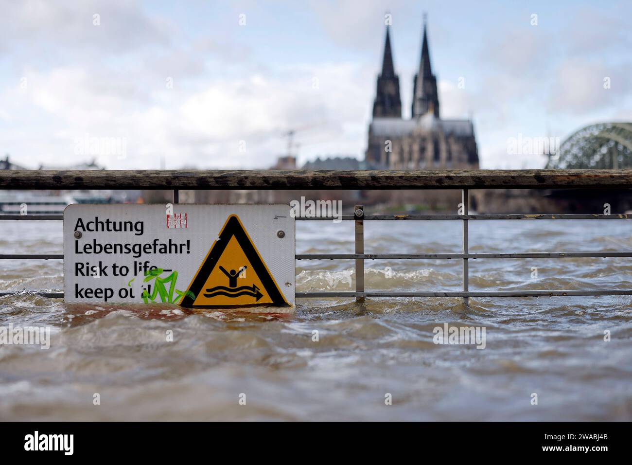Impression vom Hochwasser in Köln am Ufer von Köln-Deutz: Am Ufer des Rhein sind Teile des Rheinboulevard, Gehwege und Wiesen überflutet. Absperrungen weisen auf Lebensgefahr bei Hochwasser Hin. DAS nasse Wetter Hat die Pegel von Bächen und Flüssen steigen lassen. Böden sind aufgeweicht und können kein weiteres Wasser fassen. für die kommenden Tage wird Dauerregen befürchtet. Themenbild, Symbolbild Köln, 03.01.2024 NRW Deutschland *** impressione delle inondazioni a Colonia sulle rive di Colonia Deutz sulle rive del Reno, parti del RheinBoulevard, sentieri e prati sono allagati Bar Foto Stock