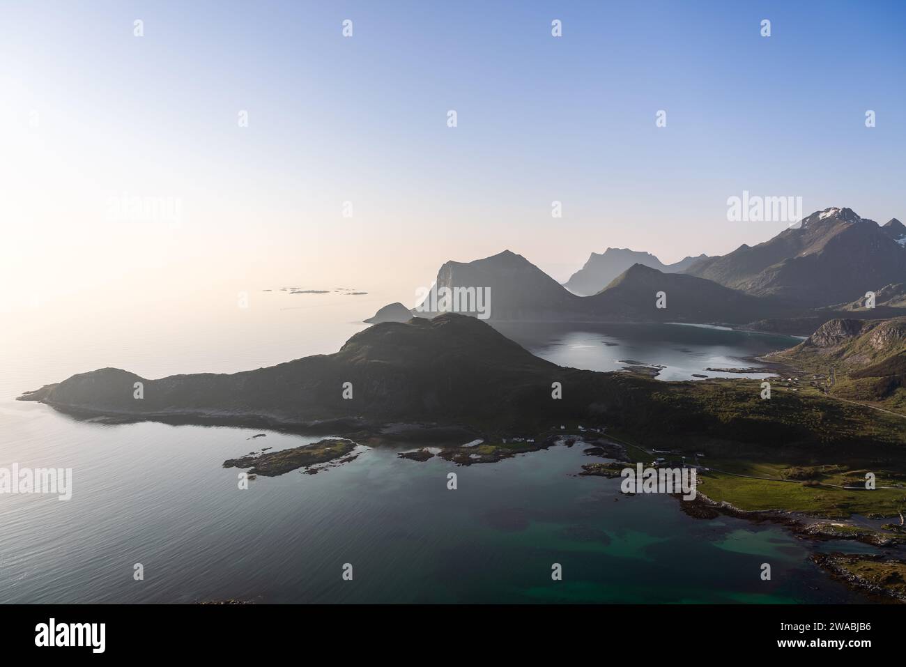 Un paradiso per gli escursionisti, questa vista dall'Offersoykammen Trail nel Lofoten, Norvegia, rivela le acque cristalline dell'arcipelago e le vette taglienti Foto Stock