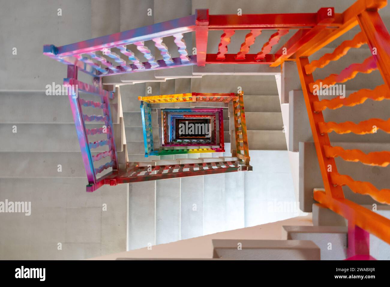 Scala a spirale colorata vista dall'alto per creare un motivo geometrico e una profondità. Foto Stock