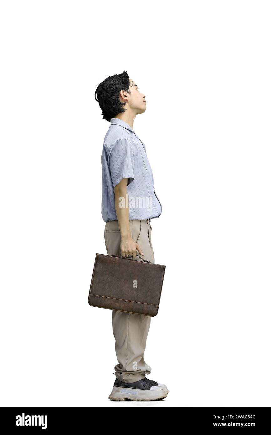 Un tizio con una camicia blu, su sfondo bianco, a tutta lunghezza, con una valigetta Foto Stock Un tizio con una camicia blu, su sfondo bianco, a tutta lunghezza, con una valigetta Foto Stock