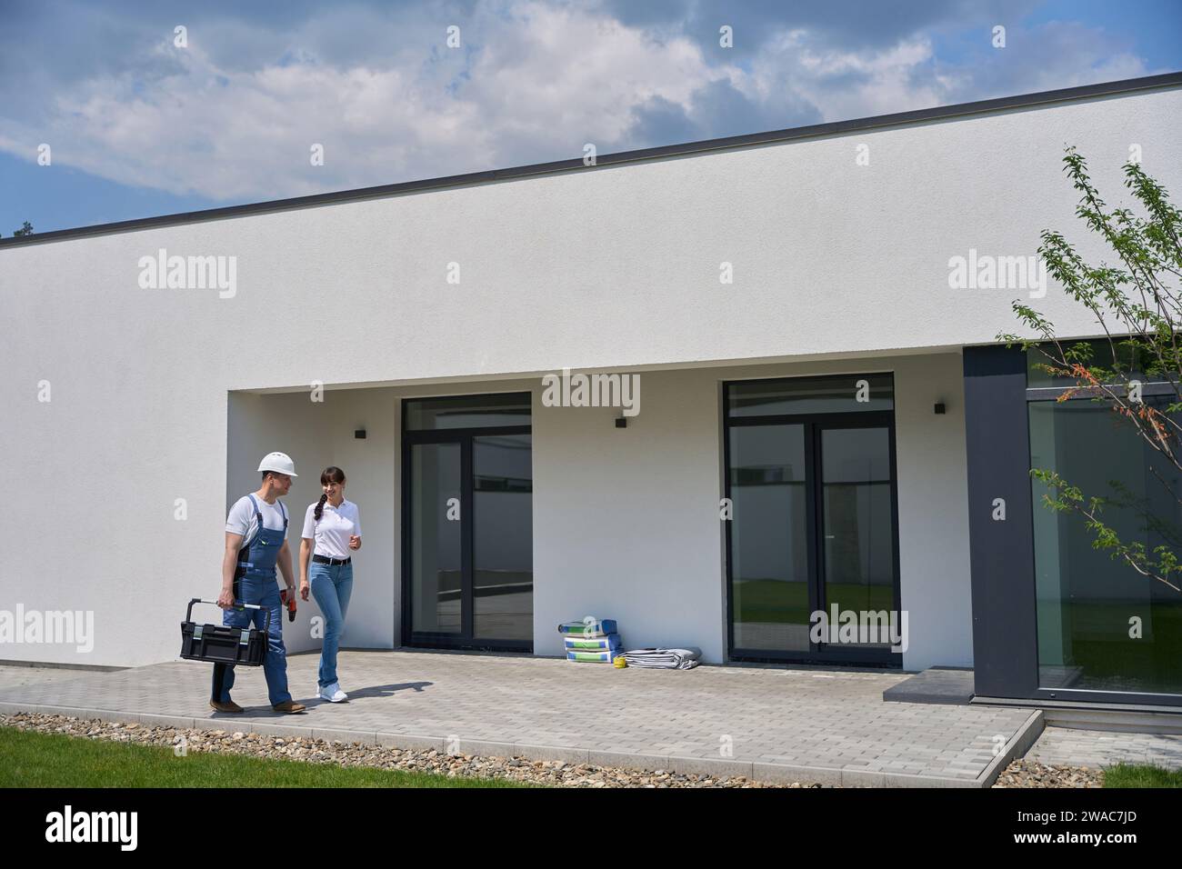 Donna che dice al riparatore mentre va sulla terrazza della casa cittadina Foto Stock