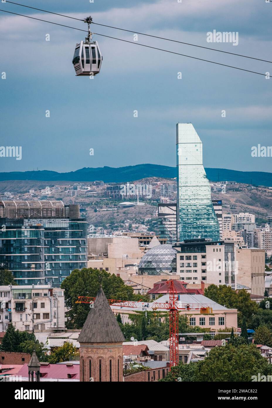Vista sul grattacielo di vetro dell'hotel Biltmore e una funivia di Tbilisi nella città vecchia di Tbilisi, Georgia Foto Stock