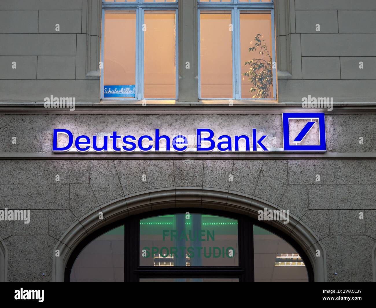 Logo della Deutsche Bank illuminato sull'esterno di un edificio. Il grande istituto bancario tedesco è sistemicamente rilevante. L'azienda ha delle filiali. Foto Stock