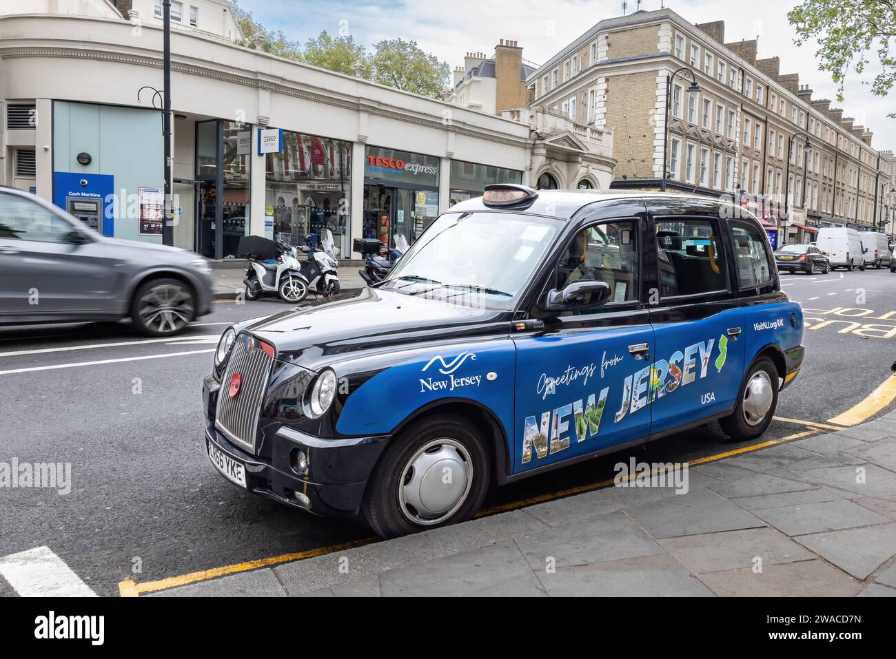 Londra, Regno Unito - 19 maggio 2023: Taxi di Londra parcheggiato, decorato in blu con la pubblicità del New Jersey, Stati Uniti. A Londra, Regno Unito Foto Stock