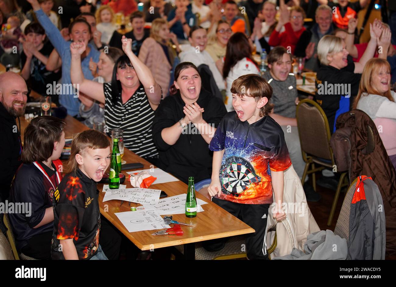 I membri del club locale di Luke Littler, la St Helen's Darts Academy, lo guardano giocare contro Luke Humphries nella finale del World Darts Championship. Il sedicenne è il giocatore più giovane di sempre a raggiungere il decisivo in un viaggio memorabile all'Alexandra Palace, ma dovrà affrontare il test più duro di sempre contro il nuovo numero uno del mondo mentre tenta di diventare il più giovane vincitore di sempre. Data foto: Mercoledì 3 gennaio 2024. Foto Stock