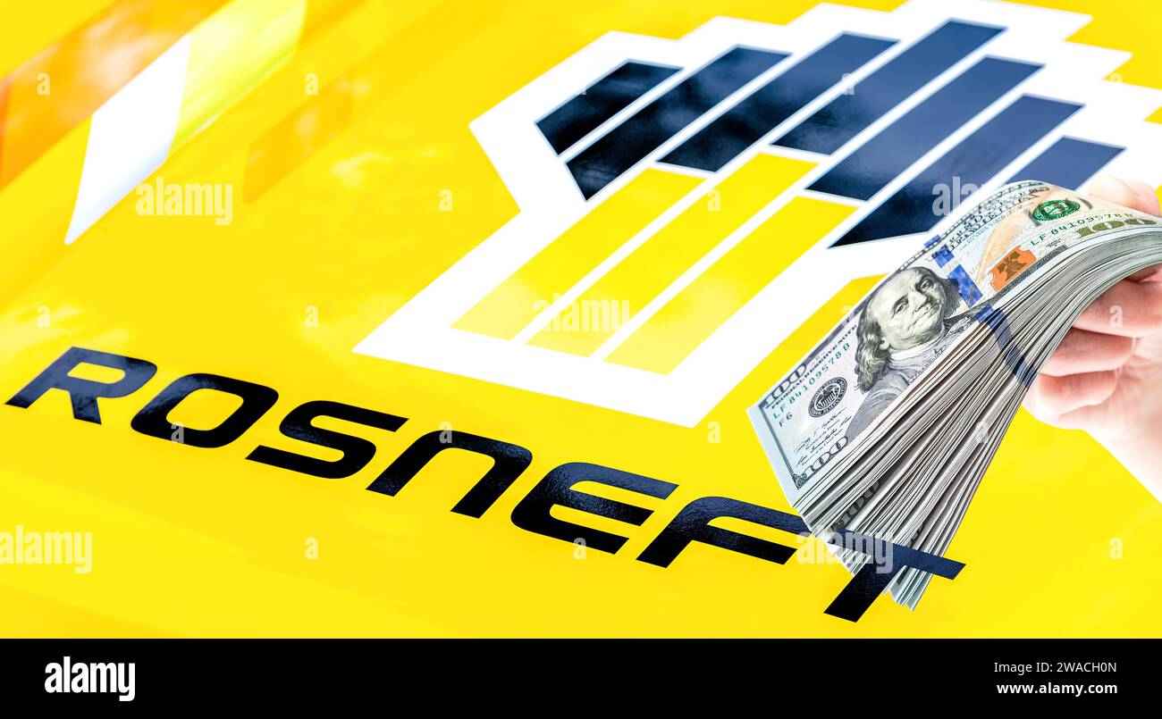 Samara, Russia - 27 maggio 2023: Logo della Rosneft Oil Company e stack di dollari americani in mano. Rosneft è una delle più grandi compagnie petrolifere russe Foto Stock