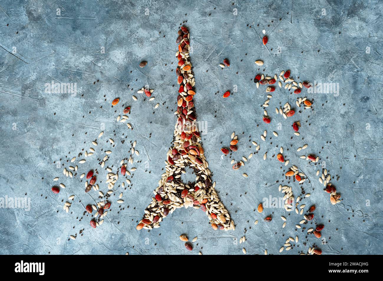 Disegno della Torre Eiffel composto da semi colorati su sfondo grigio. Paesi produttori di cereali. Vista dall'alto Foto Stock
