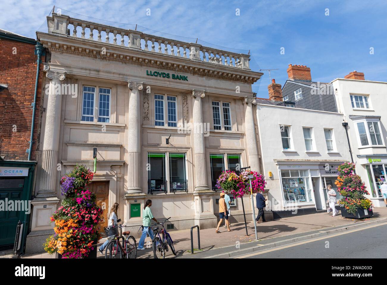 Lloyds Bank, filiale della Lloyds Bank sulla strada principale di Sidmouth, Devon, Inghilterra, soleggiata giornata autunnale con cestini in fiore, Inghilterra, 2023 Foto Stock