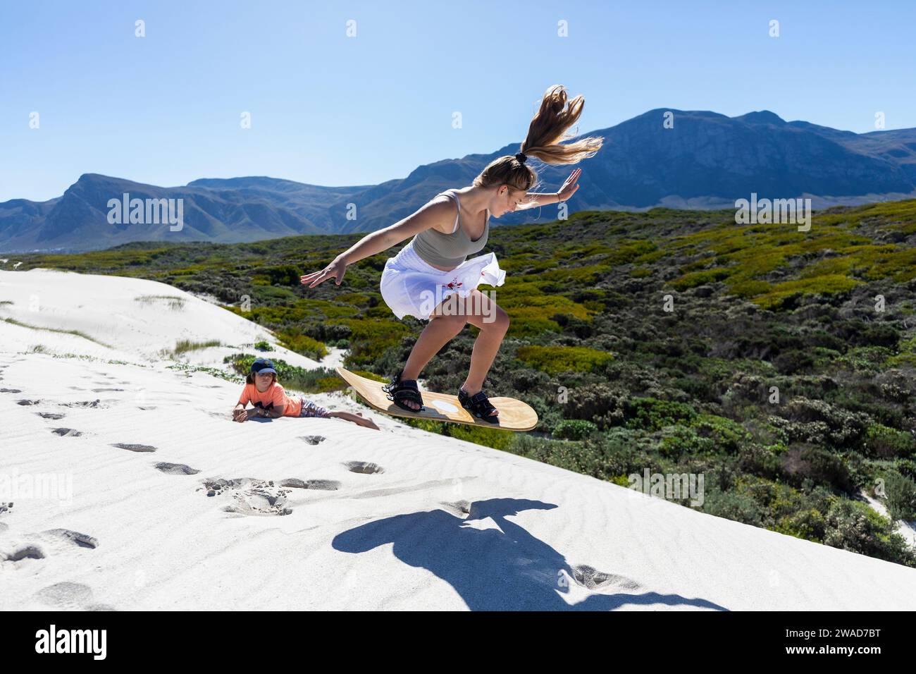 Sudafrica, sandboarding adolescente (16-17) e ragazzo (10-11) nella riserva naturale di Walker Bay Foto Stock