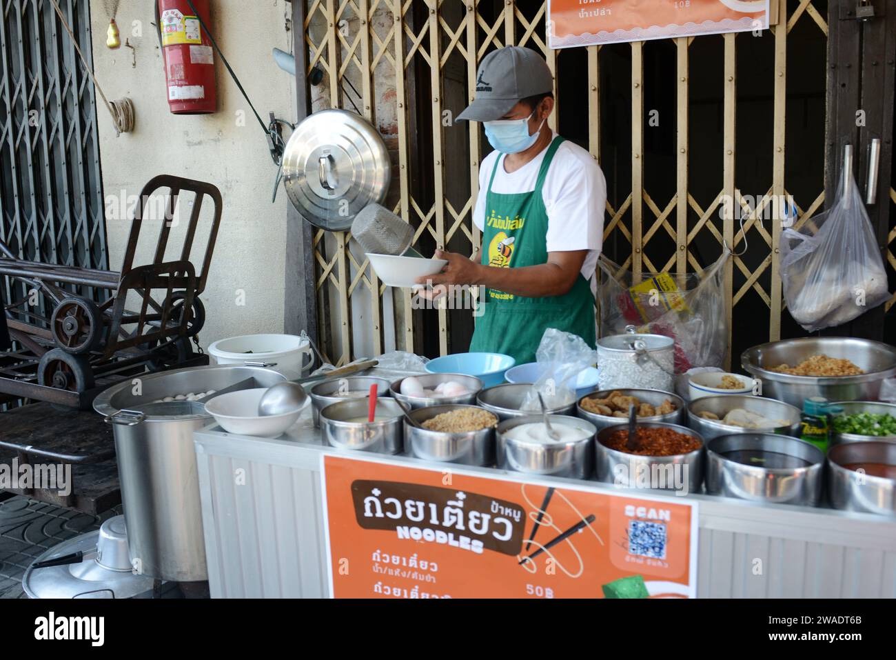 Un venditore ambulante che prepara cibo tailandese a Bangkok, Thailandia. Foto Stock