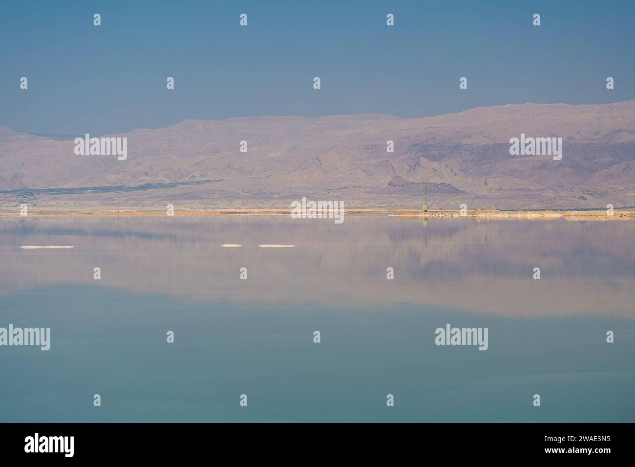 Paesaggio del Mar morto, montagne aride che si riflettono sul lago di superficie Foto Stock