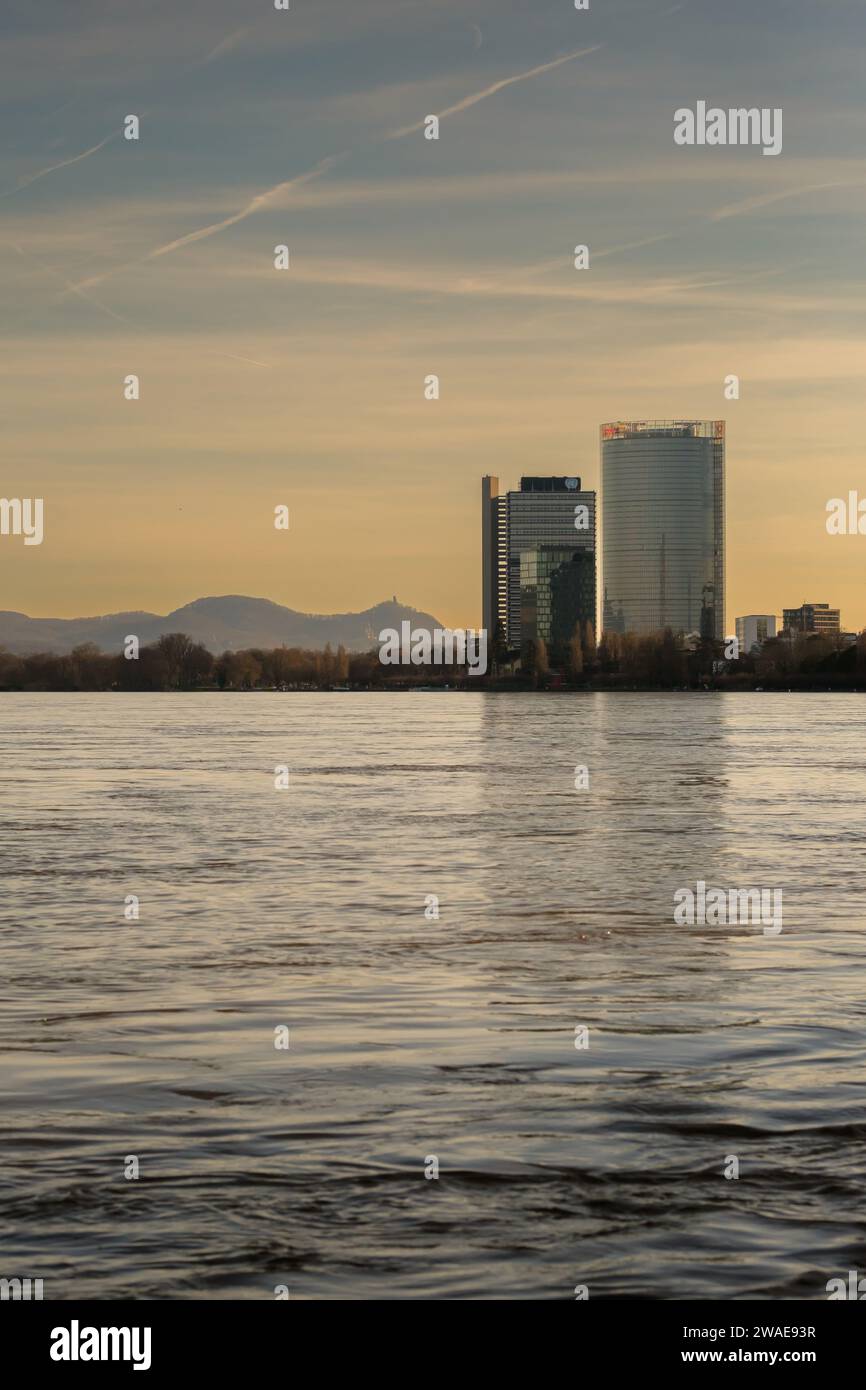 Bonn, Germania - 17 dicembre 2023: Veduta del fiume Reno gonfio, del Campus delle Nazioni Unite e della Torre della posta sullo sfondo a Bonn, Germania Foto Stock
