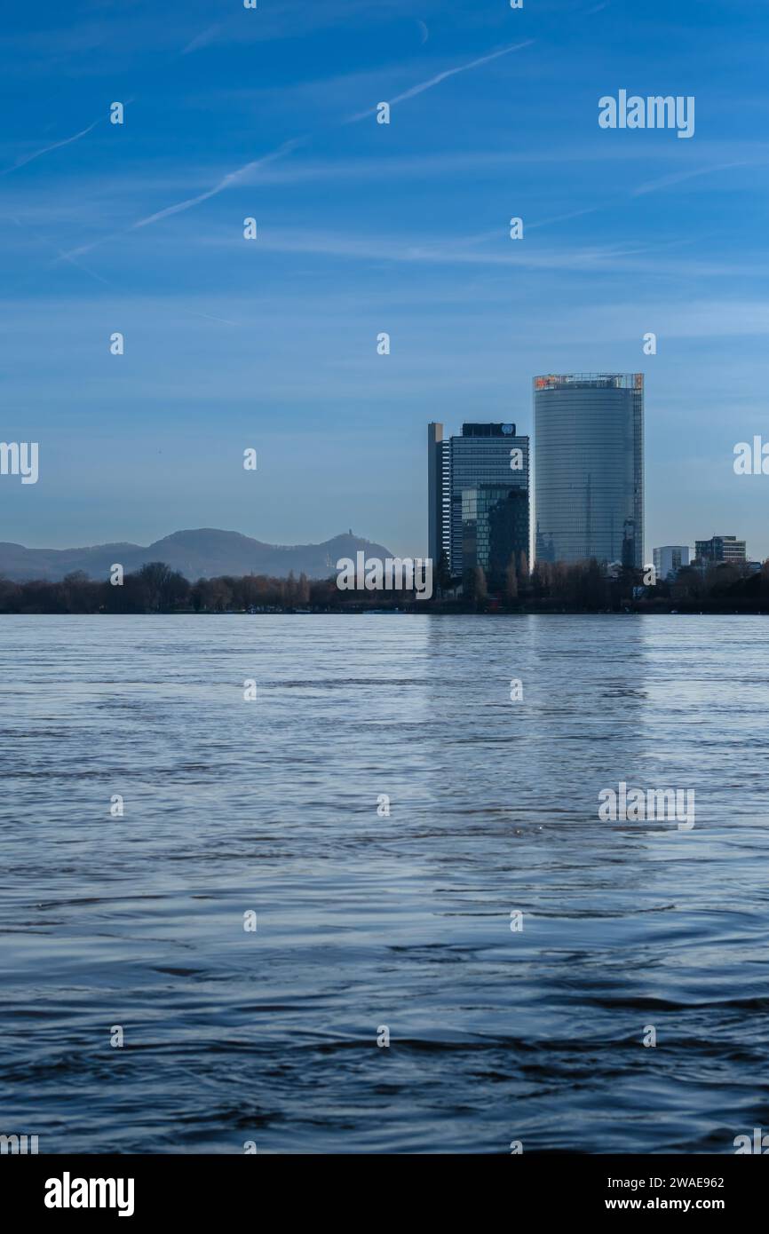 Bonn, Germania - 17 dicembre 2023: Veduta del fiume Reno gonfio, del Campus delle Nazioni Unite e della Torre della posta sullo sfondo a Bonn, Germania Foto Stock