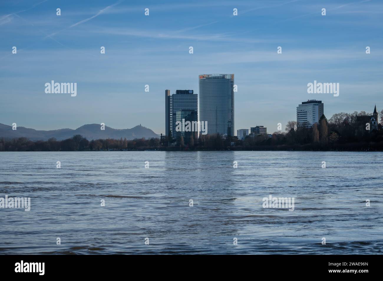 Bonn, Germania - 17 dicembre 2023: Veduta del fiume Reno gonfio, del Campus delle Nazioni Unite e della Torre della posta sullo sfondo a Bonn, Germania Foto Stock