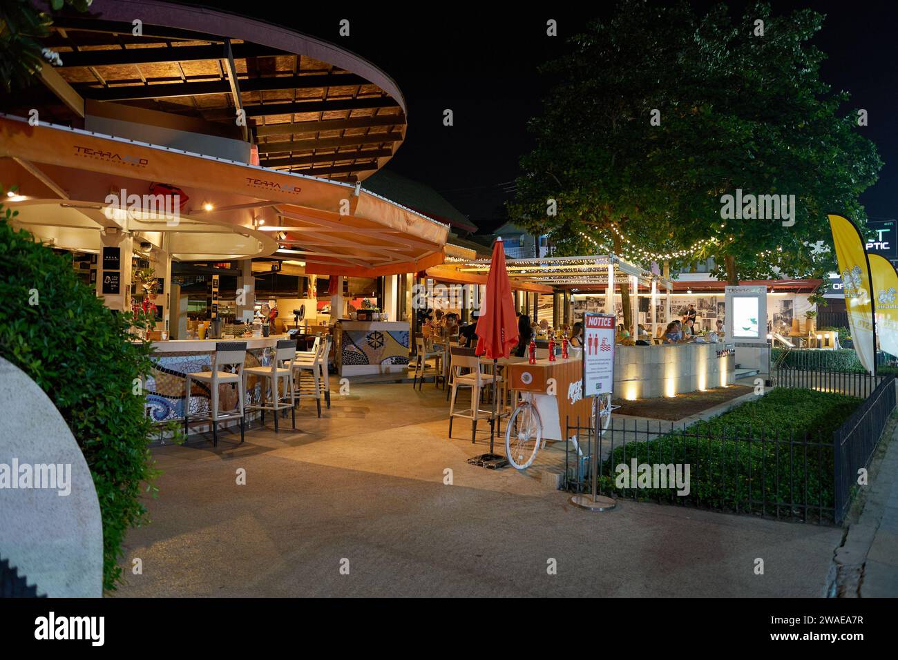 PHUKET, THAILANDIA - 15 APRILE 2023: Vista a livello della strada del terrazzo ristorante all'Holiday Inn Resort Phuket di notte. Foto Stock