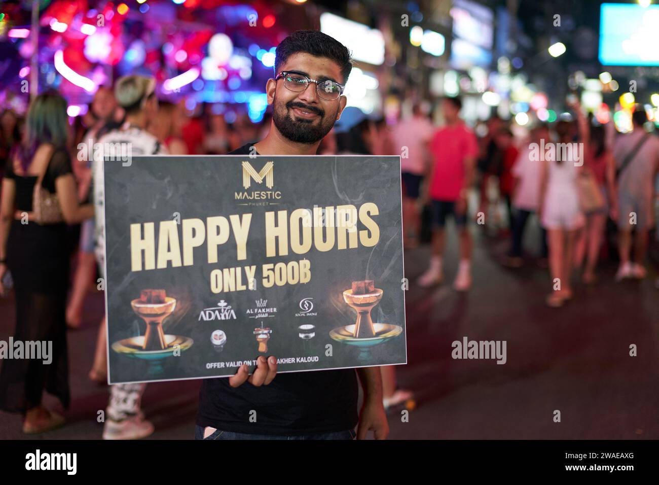 PHUKET, THAILANDIA - 25 APRILE 2023: Uomo con poster pubblicitario su Patong Beach Bangla Walking Street di notte. Foto Stock