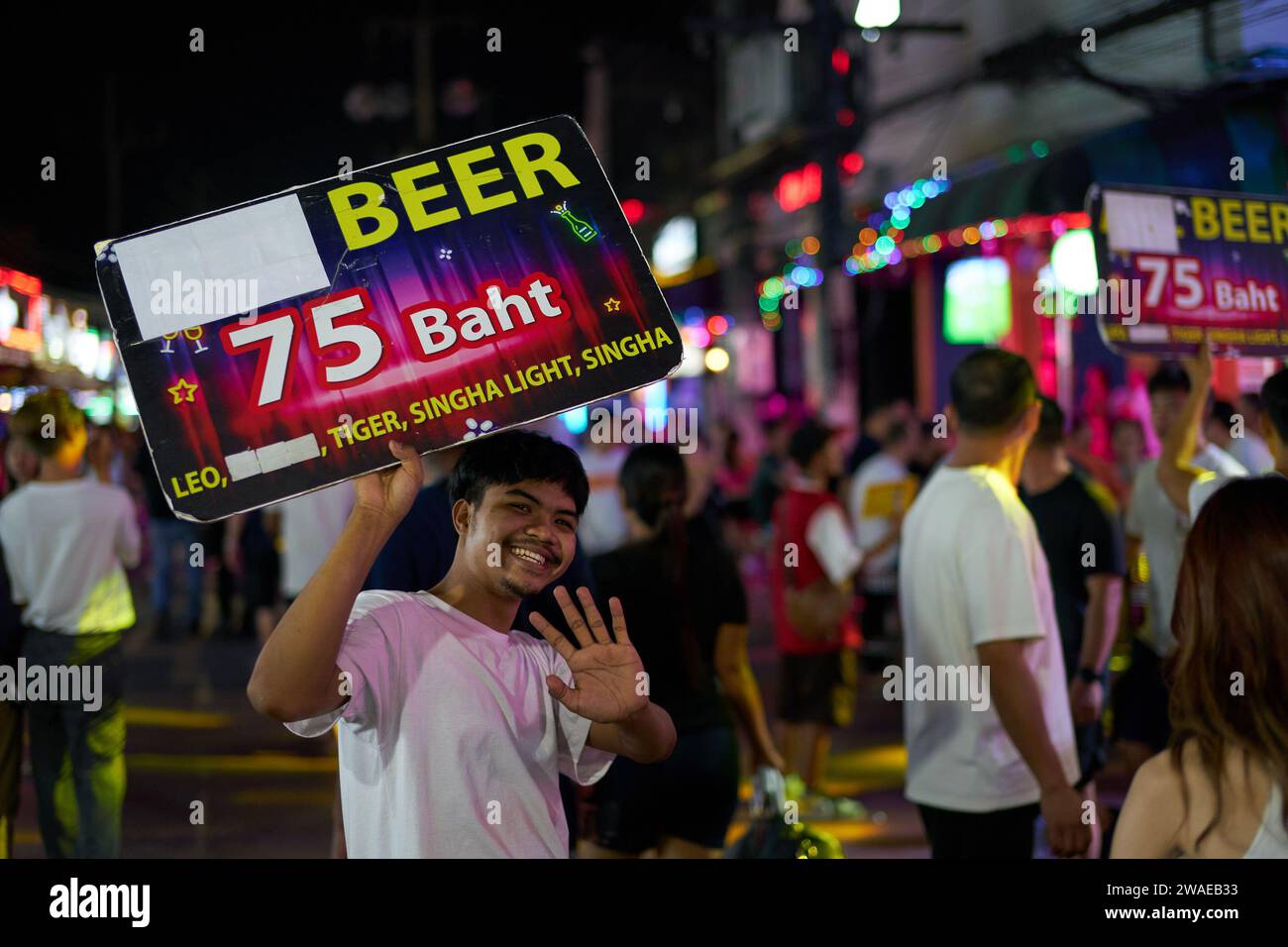 PHUKET, THAILANDIA - 25 APRILE 2023: Uomo con poster pubblicitario su Patong Beach Bangla Walking Street di notte. Foto Stock