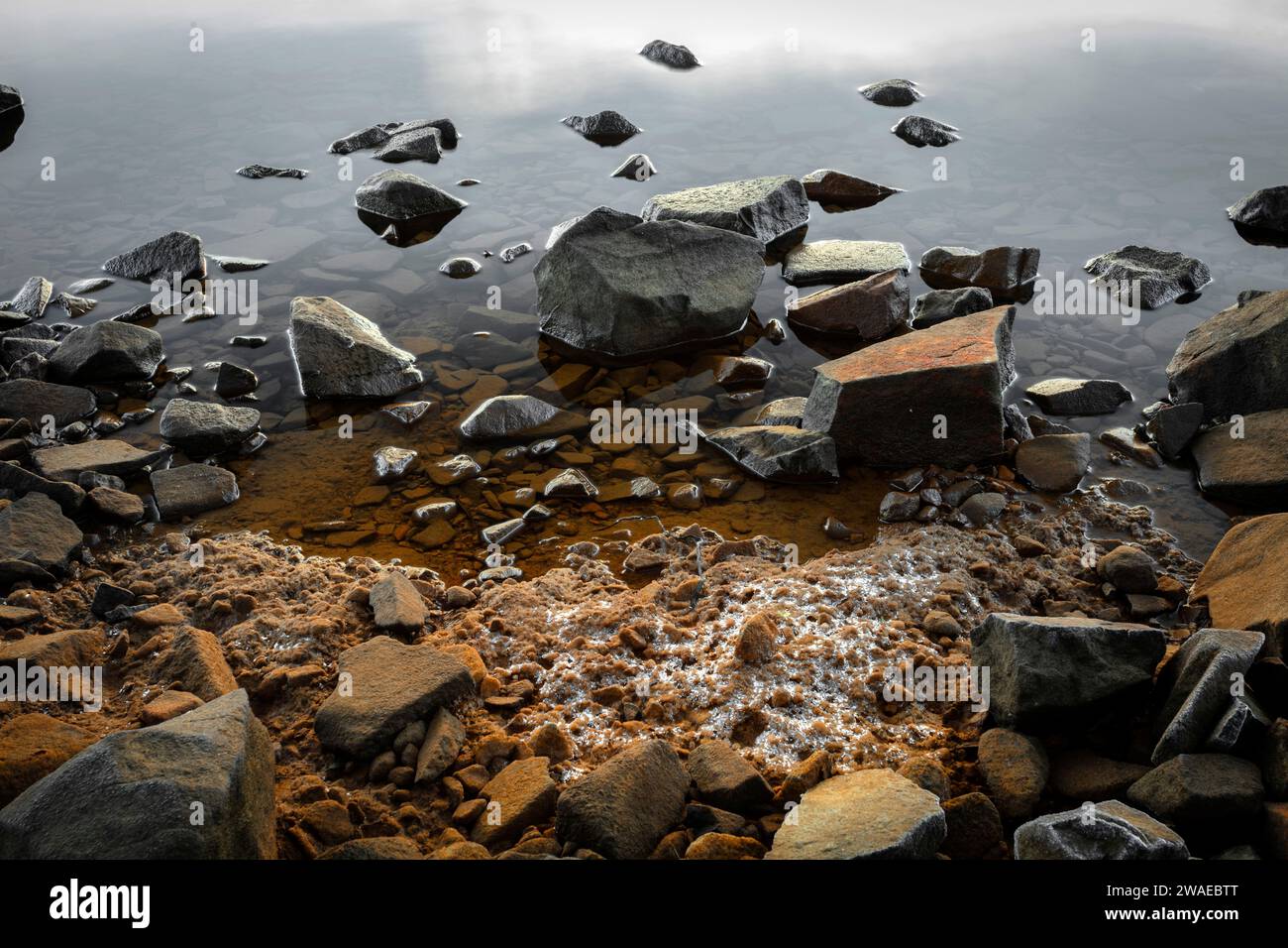 Una spiaggia tranquilla con rocce che creano un'atmosfera tranquilla e rilassante Foto Stock