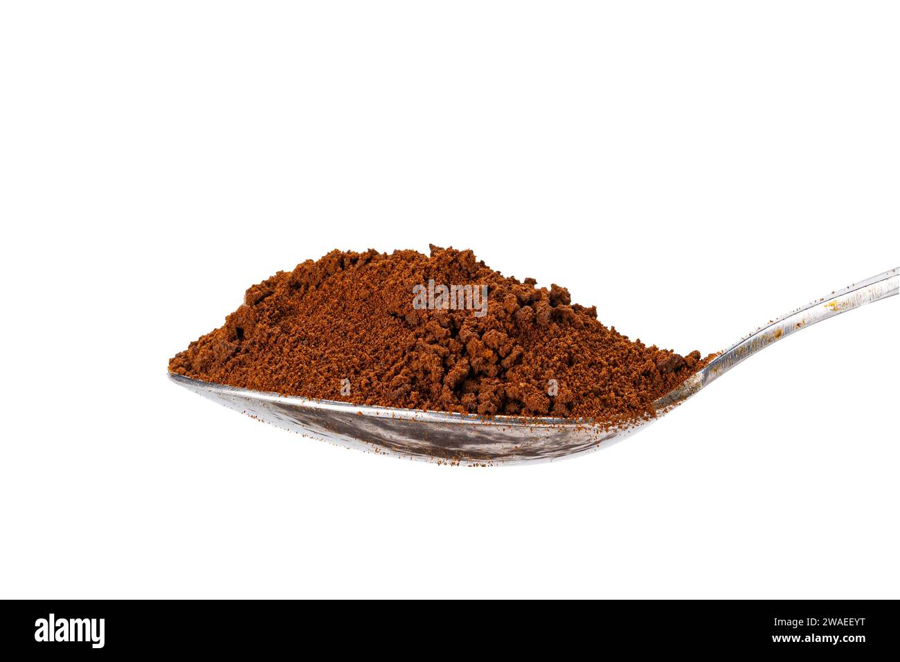 Vista laterale della polvere di caffè solubile organico in un cucchiaino di metallo isolato su sfondo bianco con percorso di ritaglio. Foto Stock