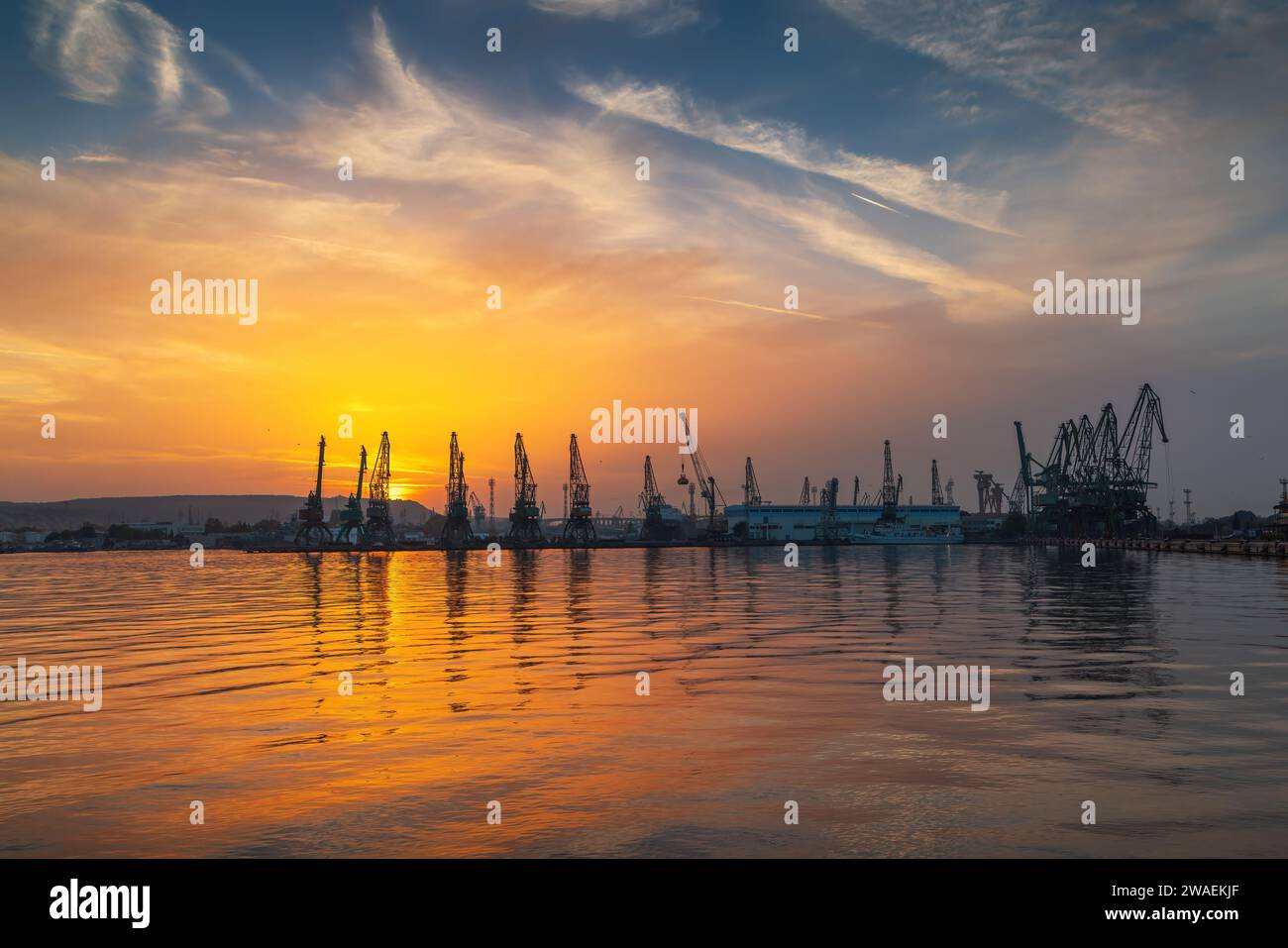 Tramonto sul porto marittimo e sulle gru industriali, Varna Bulgaria Foto Stock