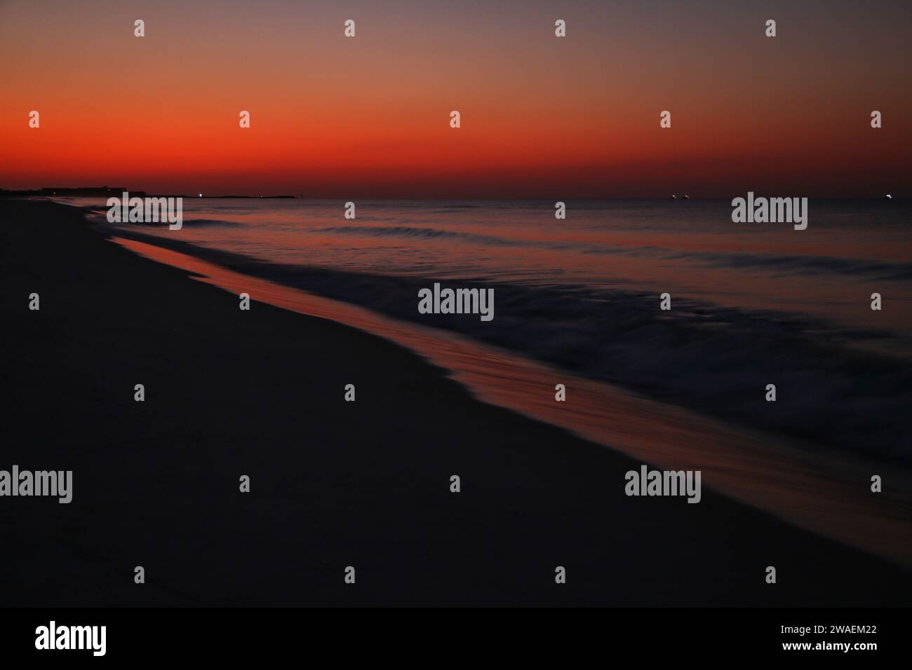 Un idilliaco scenario balneare al tramonto con un cielo tranquillo e onde morbide a Destin, Florida Foto Stock