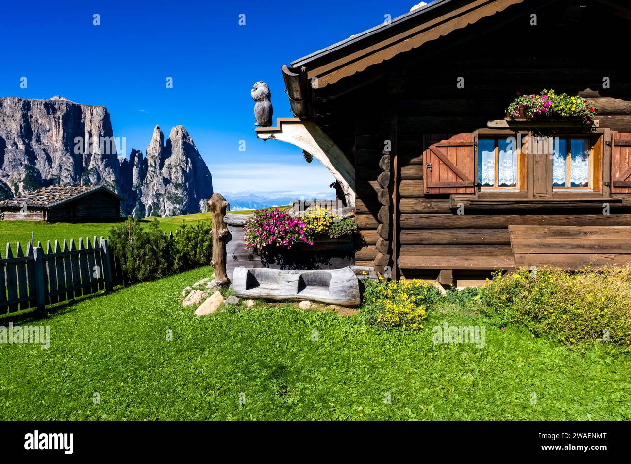 Una casa in legno sulla cima di una collina all'Alpe di Siusi, l'Alpe di Siusi, il monte Sciliar, in lontananza. Foto Stock
