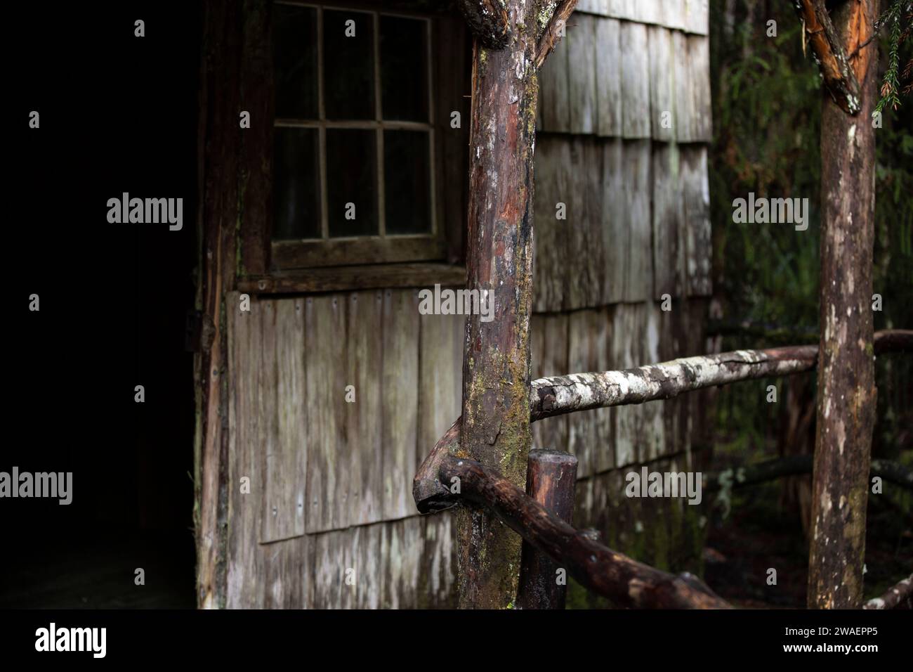 Una recinzione in legno d'epoca circonda un capannone in decomposizione Foto Stock