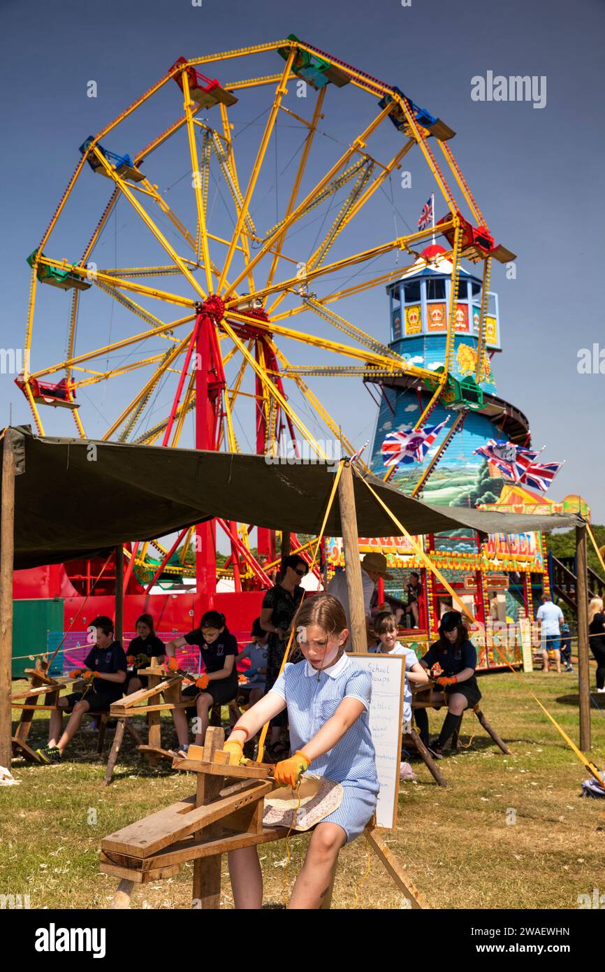 Regno Unito, Inghilterra, Worcestershire, Malvern Wells, Royal 3 Counties Show, bambini che usano il spokeshave sotto Old Tyme Fun Fair Foto Stock