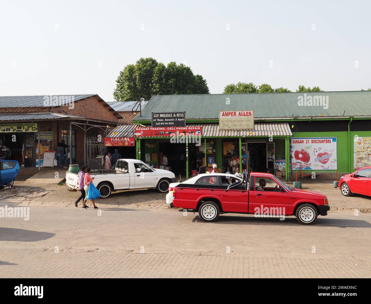 Scena di strada a Graskop, Mpumalanga, Sud Africa, con tipici negozi, veicoli e gente di piccole città. Foto Stock