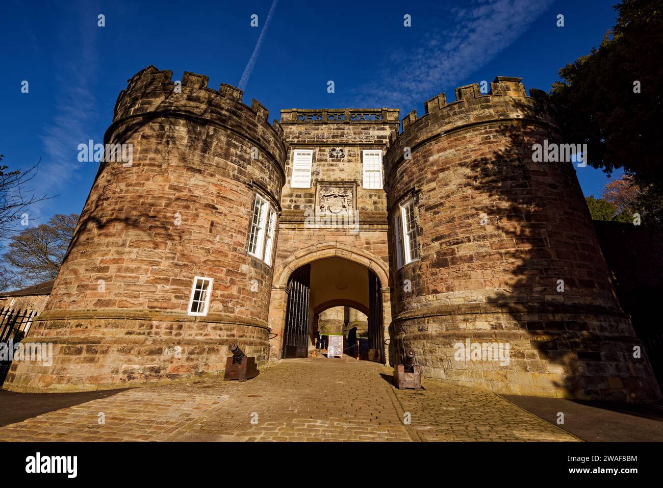 Le imponenti torri gemelle della porta d'ingresso al Castello di Skipton bagnate dal sole con un cielo intensamente blu, il North Yorkshire. Foto Stock