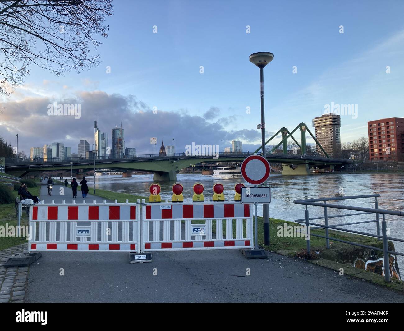 4 gennaio 2024, Assia, Francoforte sul meno: Un cartello sulle rive del meno a Francoforte avverte di inondazioni. La pista ciclabile e pedonale sul lato di Sachsenhausen, approssimativamente a livello della BCE opposta, è stata cordonata. (A dpa: 'No Easing of Floods yet - Main Moves into Focus') foto: Isabell Scheuplein/dpa Foto Stock