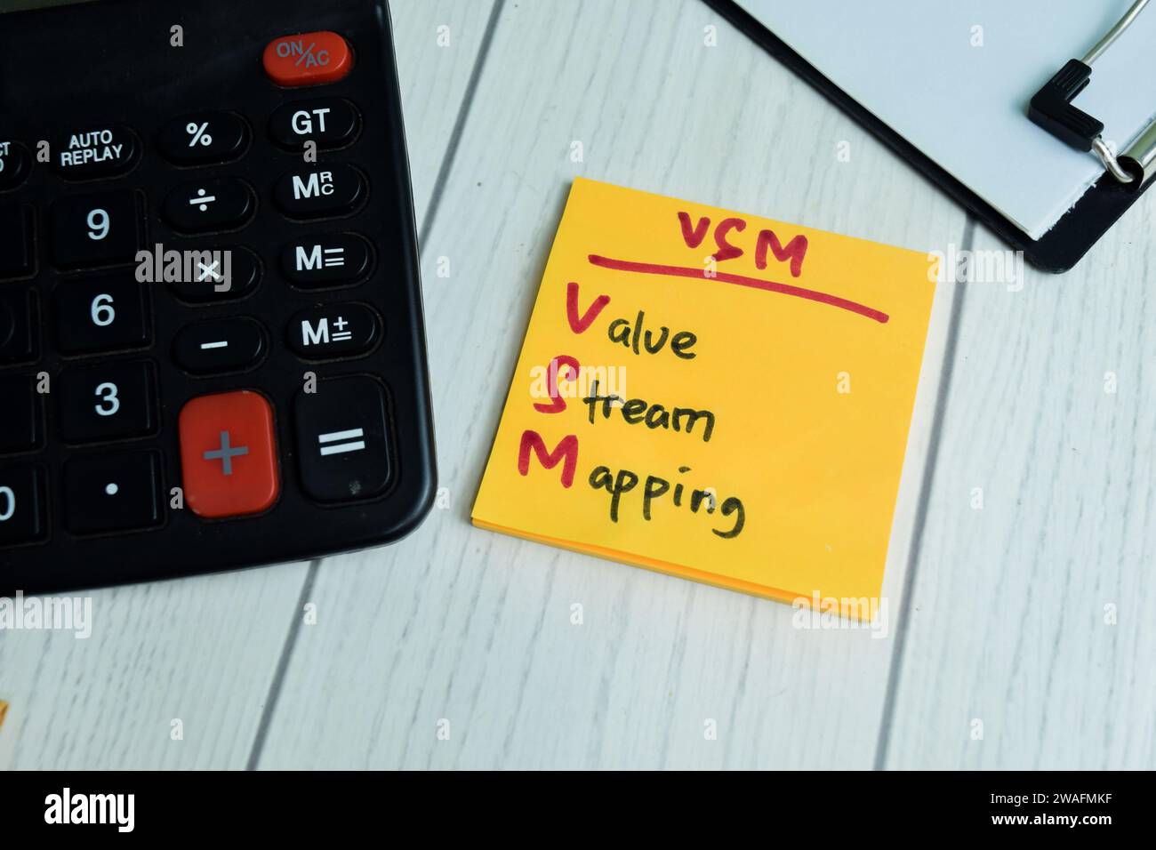 Concetto di VSM - Value Stream Mapping scrivere su note appiccicose isolate su tavola di legno. Foto Stock