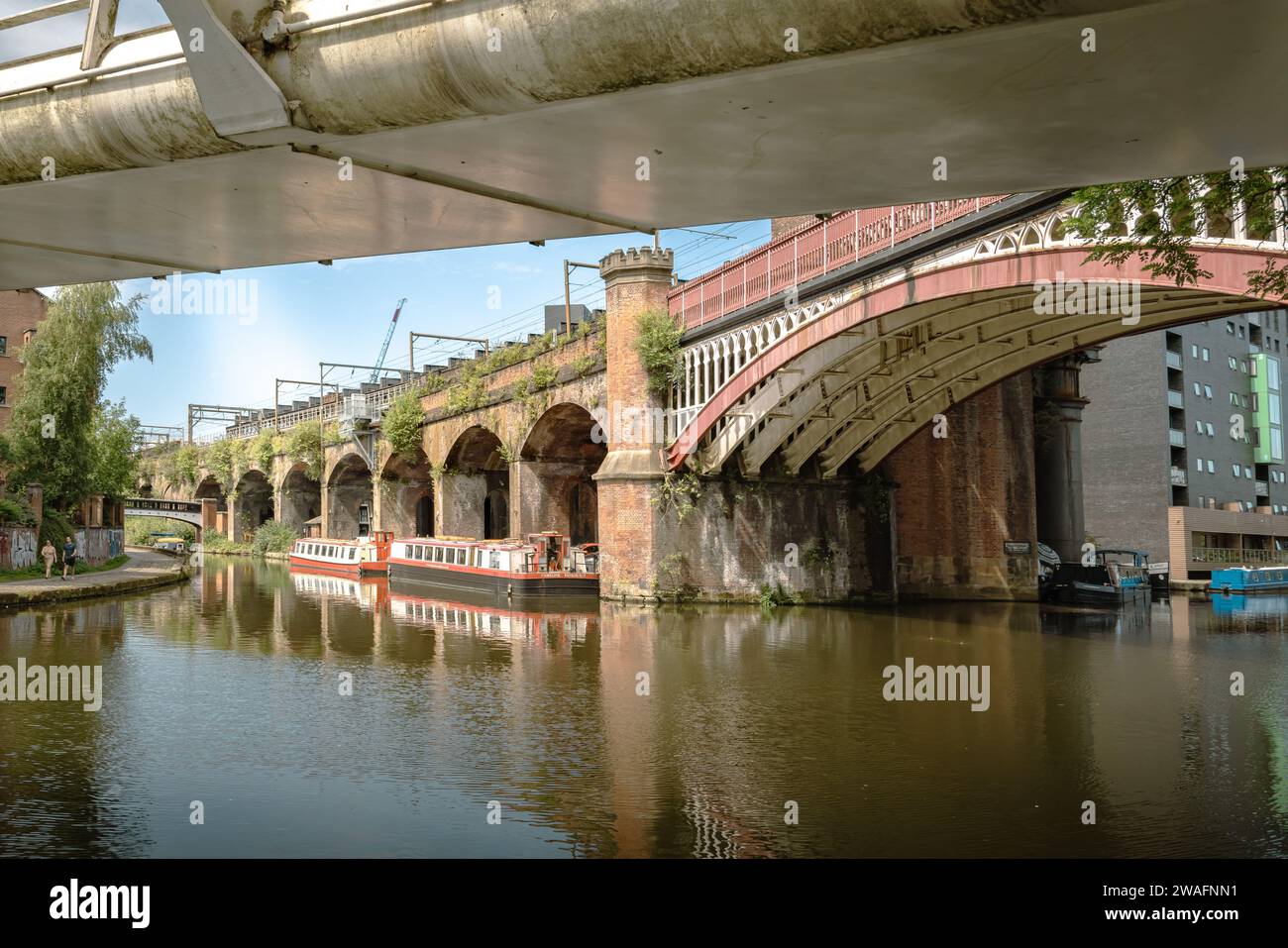 Il tranquillo Manchester Bridgwater Canal fiancheggiato da uno storico ponte ad arco. Fascino urbano in un ambiente tranquillo sul mare. Concetto di turismo di viaggio Foto Stock