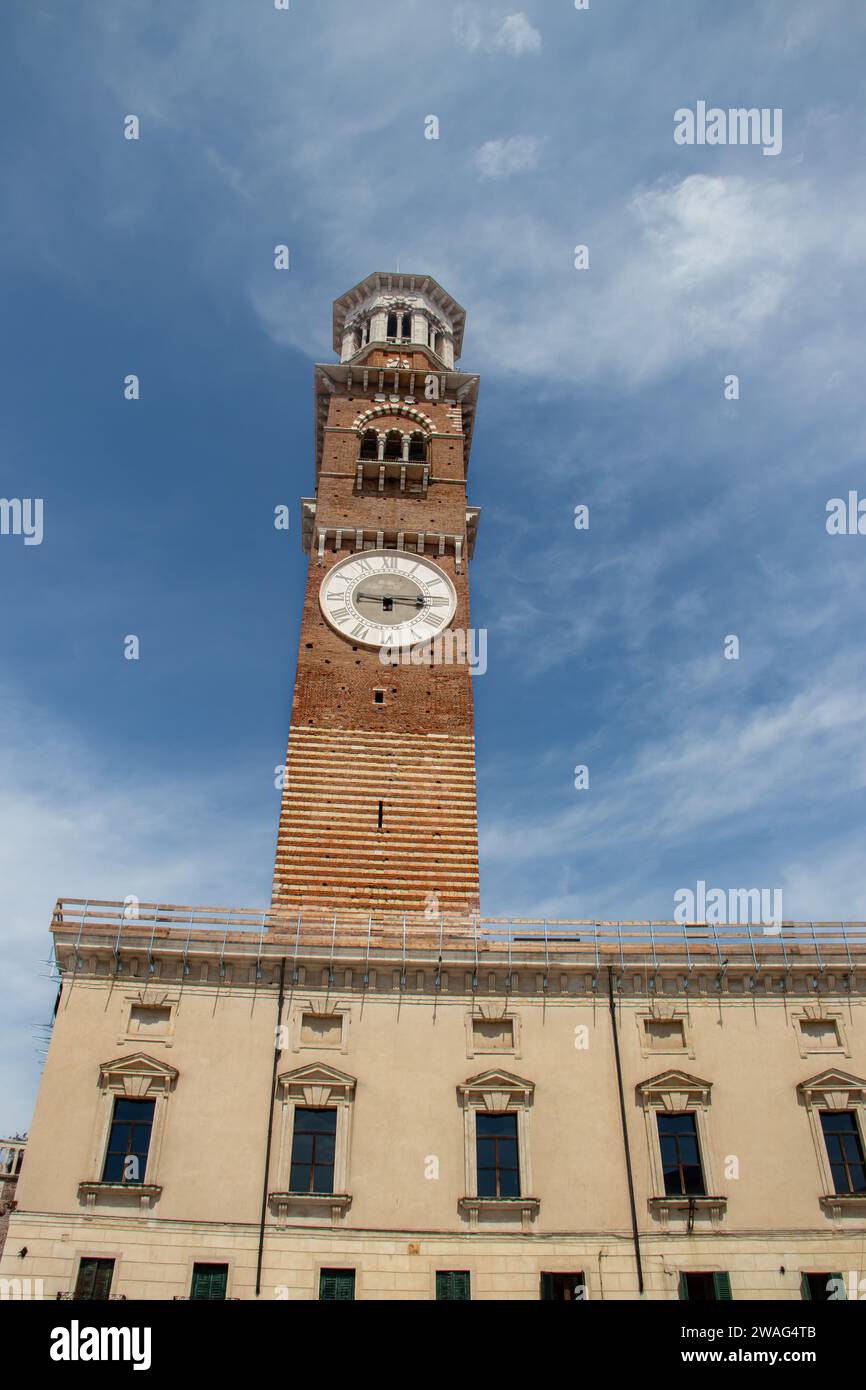 Lamberti medievale (Torre dei Lamberti) Torre del XI secolo con orologio, 84 metro e antica antica colonna (1400 a.D) su Piazza Erbe nella città di Verona. Foto Stock