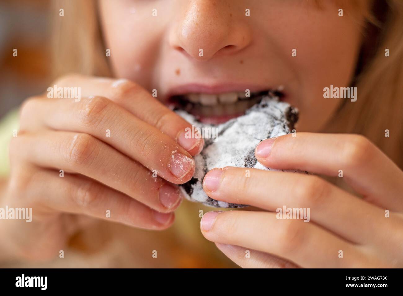 ragazza che tiene biscotti brownie con le mani per mangiare Foto Stock