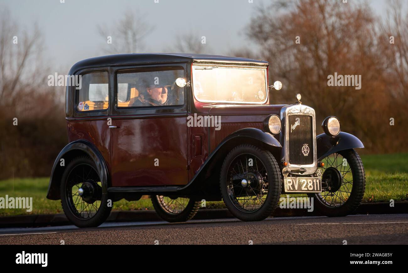 Stony Stratford, Regno Unito, 1 gennaio 2024. Auto Austin Seven 1932 Maroon che arriva a Stony Stratford per l'annuale New Year Day, veicolo d'epoca e classico fes Foto Stock