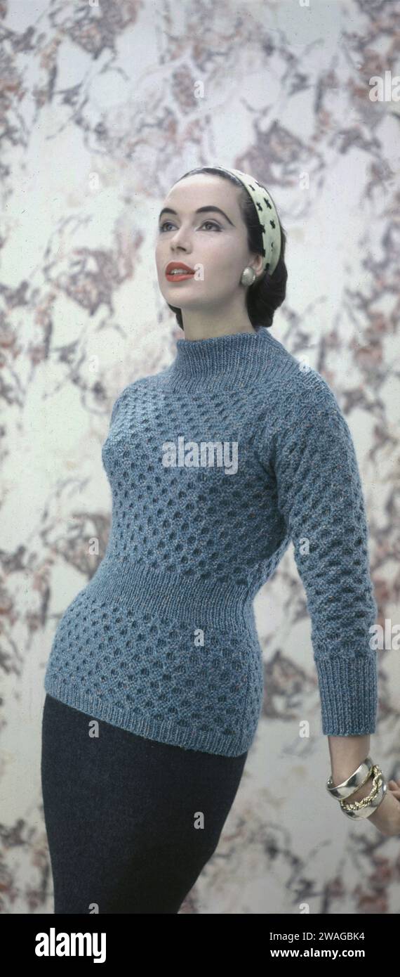 Anni '1950, storica, elegante giovane donna che modella l'ultima moda in maglia di lana manica lunga, collo alto, top sopra una gonna a tubo, Inghilterra, Regno Unito. Negli anni '1940 e '50, la lana era popolare come tessuto femminile in quanto era elegante, femminile e classico. Foto Stock