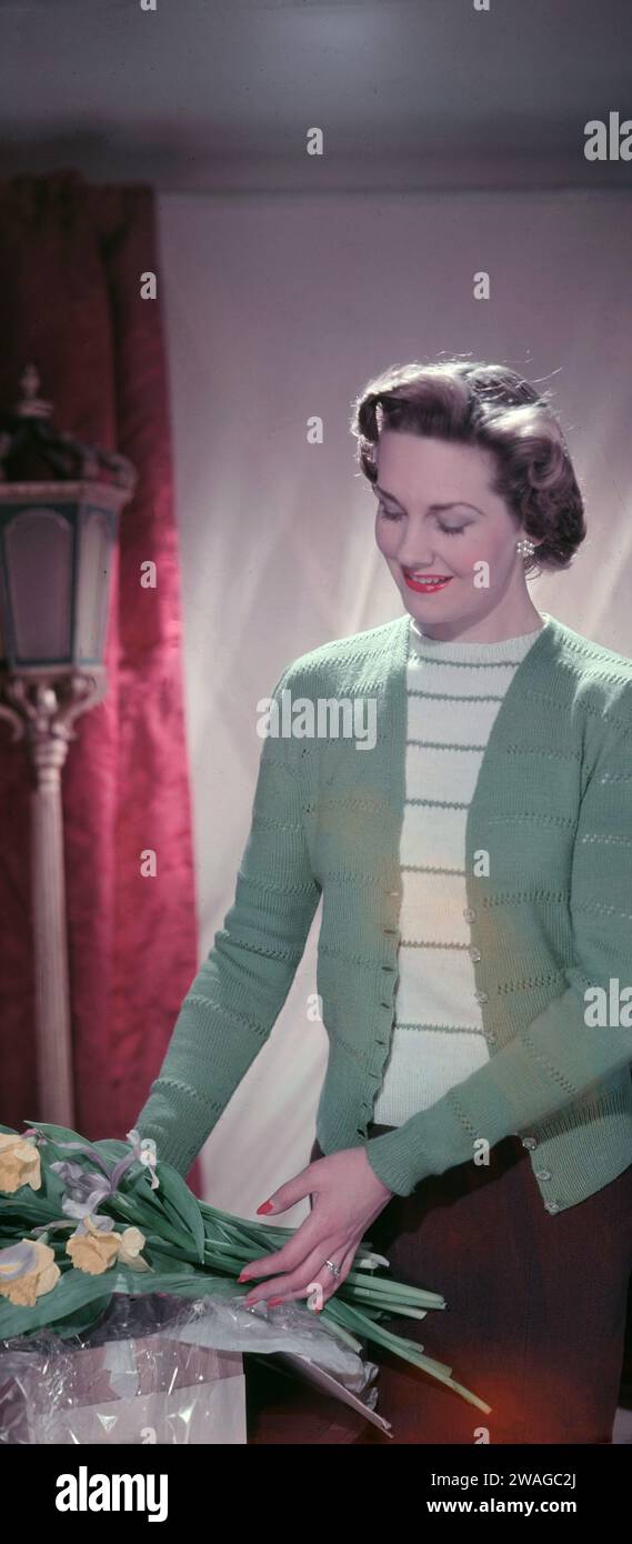 Anni '1950, storica, una giovane donna elegante, a metà degli anni '20, che modella l'ultimo cardigan a maniche lunghe in pura lana e il top girocollo, Inghilterra, Regno Unito. Foto Stock