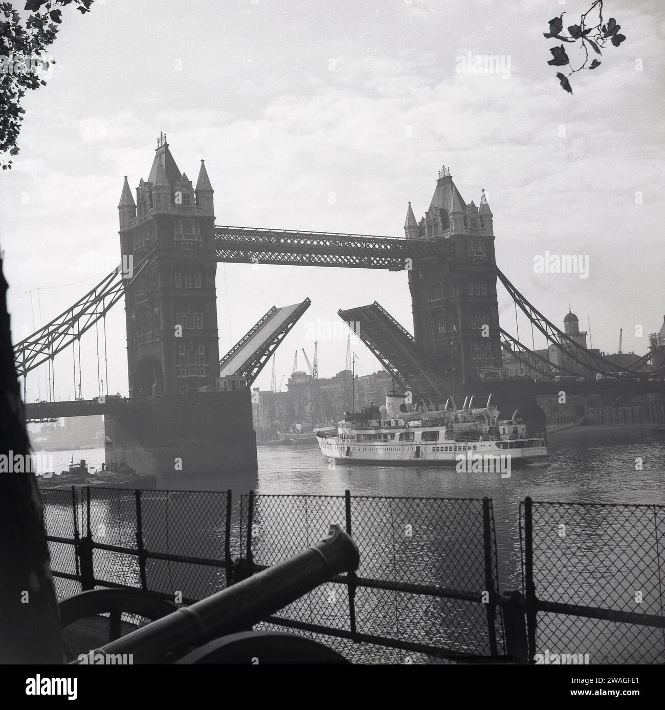 Anni '1960, storica nave passeggeri a vapore, Royal Sovereign, passando sotto il Tower Bridge, sul Tamigi, Londra, Inghilterra, Regno Unito. Costruita per la GSNSC da William Denny & Brothers a Dumbarton nel 1948, la nave da diporto trasportava passeggeri tra il Tower Pier di Londra, passando per Southend, le città costiere del Kent e i porti della Costa francese. Foto Stock
