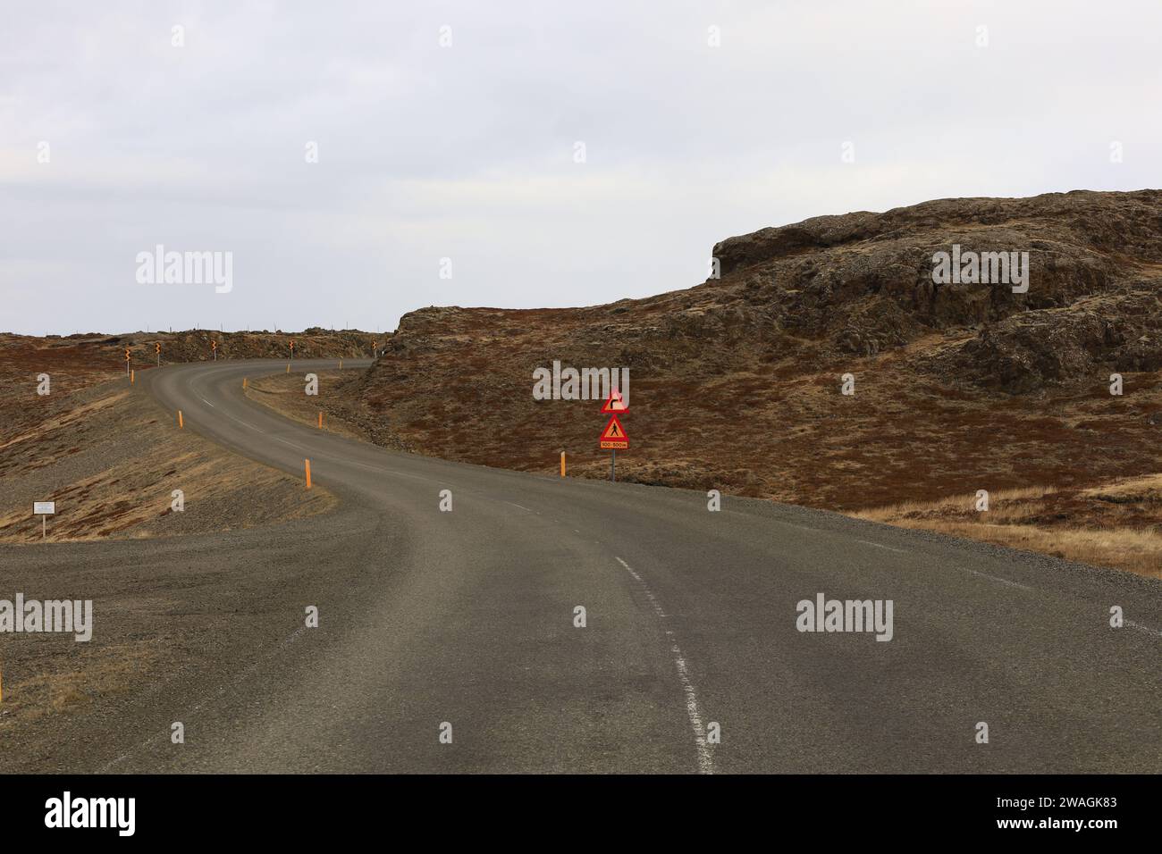 Vista su una strada nel fiordo di Fáskrúðsfjörður, nella regione dell'Austurland, nella parte orientale dell'Islanda Foto Stock