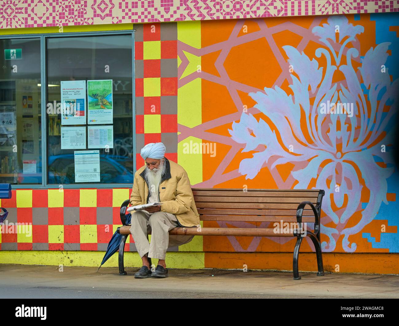 Sikh man Reading Newspaper, Sunset Multicultural Neighborhood, Fraser Street, Vancouver, British Columbia, Canada Foto Stock