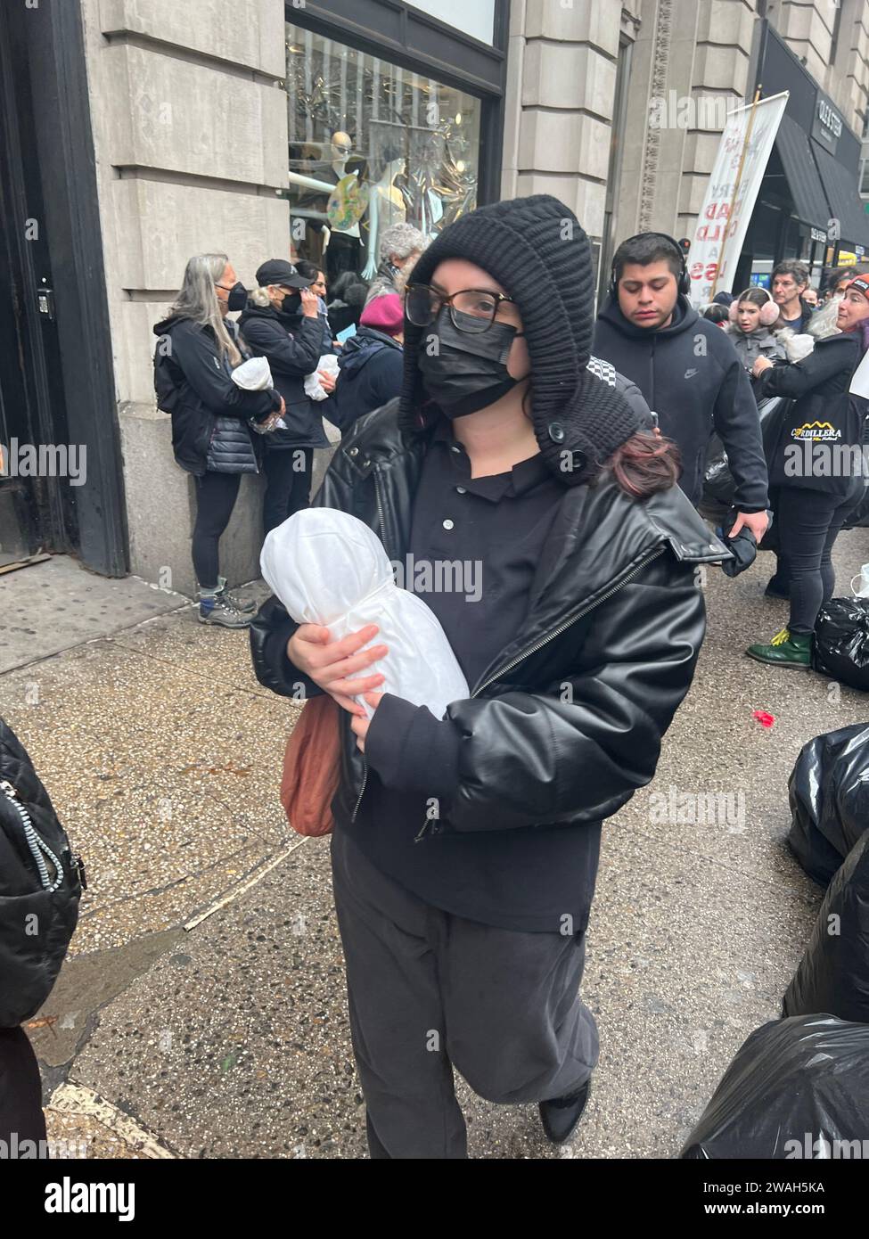 Veglia silenziosa con persone che tengono i bambini tra le braccia mentre marciano a Manhattan, ricordandoci di superare le divisioni e diventare nuovamente umani e di far sì che entrambe le parti della conflagrazione israeliana di Hamas fermino la follia. Iniziato da anziani ebrei e alleati per il cessate il fuoco. Foto Stock