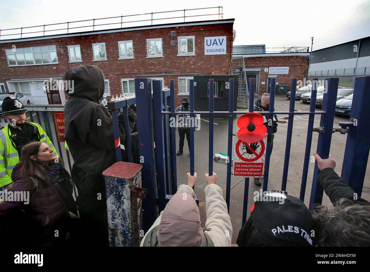 Shenstone, Regno Unito. 4 gennaio 2024. I manifestanti scuotono i cancelli fuori dalla fabbrica di droni durante la dimostrazione. I manifestanti si sono riuniti fuori dai motori UAV e hanno chiesto la sua chiusura. La società di proprietà della società israeliana di difesa Elbit Systems fornisce motori e altre parti per droni che i manifestanti dicono siano attualmente utilizzati per osservare e sparare missili da parte degli israeliani contro i civili palestinesi nella loro guerra a Gaza. (Foto di Martin Pope/SOPA Images/Sipa USA) credito: SIPA USA/Alamy Live News Foto Stock