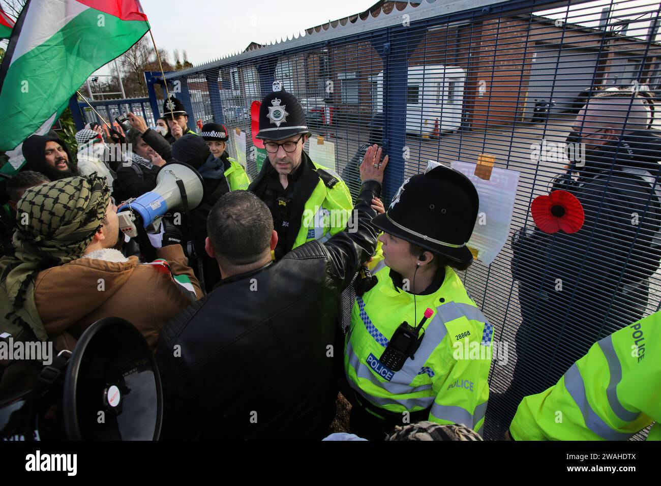 Shenstone, Regno Unito. 4 gennaio 2024. Gli agenti di polizia fermano i manifestanti fuori dalla fabbrica di droni durante la manifestazione. I manifestanti si sono riuniti fuori dai motori UAV e hanno chiesto la sua chiusura. La società di proprietà della società israeliana di difesa Elbit Systems fornisce motori e altre parti per droni che i manifestanti dicono siano attualmente utilizzati per osservare e sparare missili da parte degli israeliani contro i civili palestinesi nella loro guerra a Gaza. (Foto di Martin Pope/SOPA Images/Sipa USA) credito: SIPA USA/Alamy Live News Foto Stock