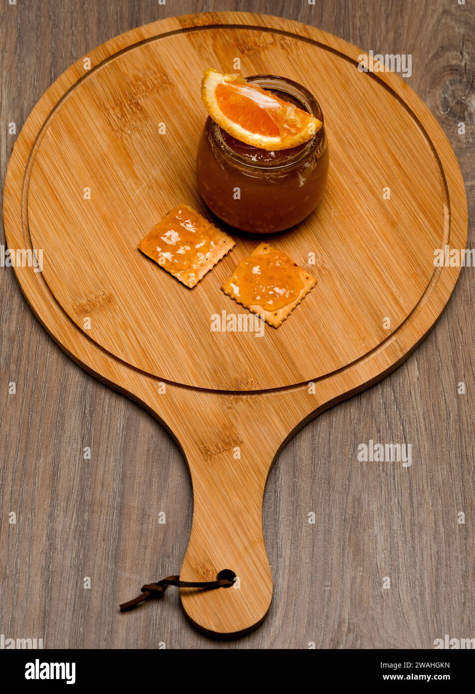 marmellata di arancio naturale su una tavola di legno con due cracker Foto Stock
